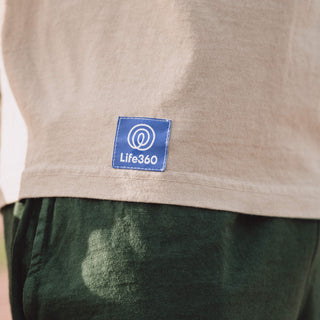 Zoomed in photo of the Purple Life360 logo tag sewn into the bottom right corner of the shirt